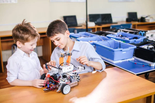 在学校机器人课上玩机器人玩具的两个兄弟孩子，室内. — 图库照片