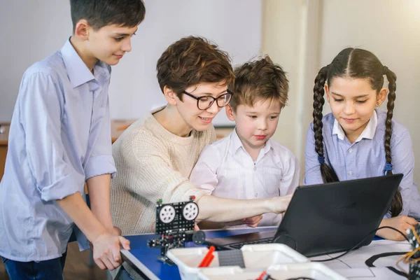 Crianças felizes aprendem programação usando laptops em aulas extracurriculares — Fotografia de Stock