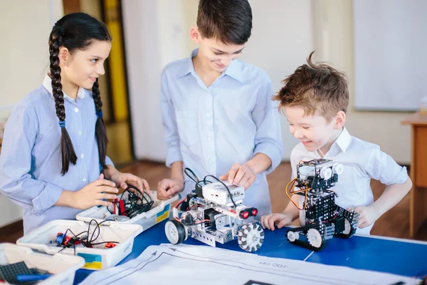 Дети играют с электрическим роботом во время посещения выставки робототехники — стоковое фото