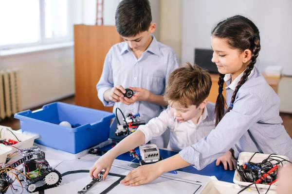 Crianças brincando com robô elétrico enquanto visitam exposição de robótica — Fotografia de Stock