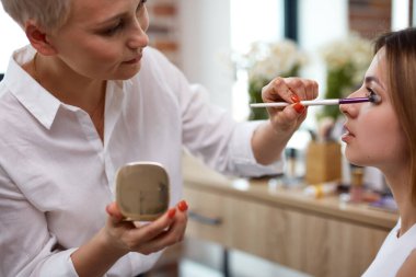 Ünlü makyöz model üzerinde makyaj yapıyor.