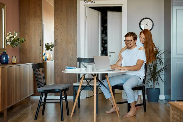 Adorable hembra abraza a su marido trabajador desde atrás — Foto de Stock