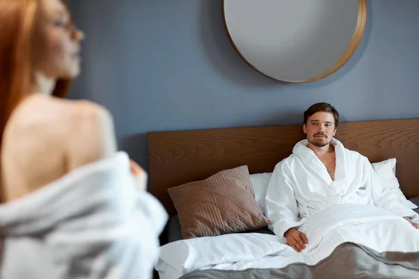 Urocza kobieta flirtuje z mężczyzną w pokoju hotelowym — Zdjęcie stockowe