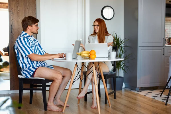 Fröhliches Paar unterhält sich bei der Arbeit zu Hause — Stockfoto