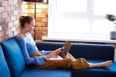 Beyaz kadın dizüstü bilgisayara bakıyor.