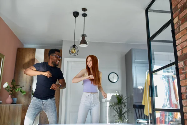 Vreugdevolle Afrikaanse man dansen met vriendin binnen — Stockfoto