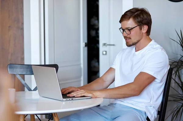 Widok z boku na pracującego człowieka z laptopem — Zdjęcie stockowe