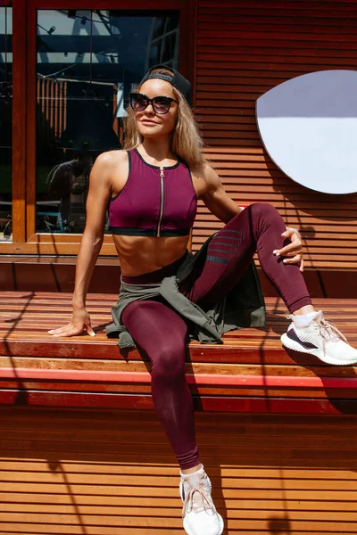 Mujer descansando en el café de verano después de un duro entrenamiento matutino. —  Fotos de Stock