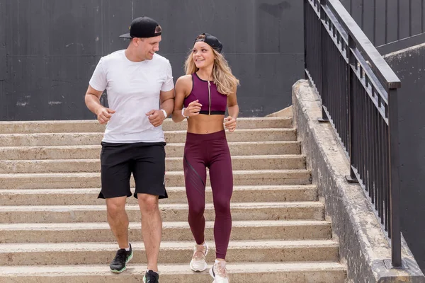 Pareja corriendo por las escaleras por la mañana, trotando en el área urbana con estrellas. — Foto de Stock