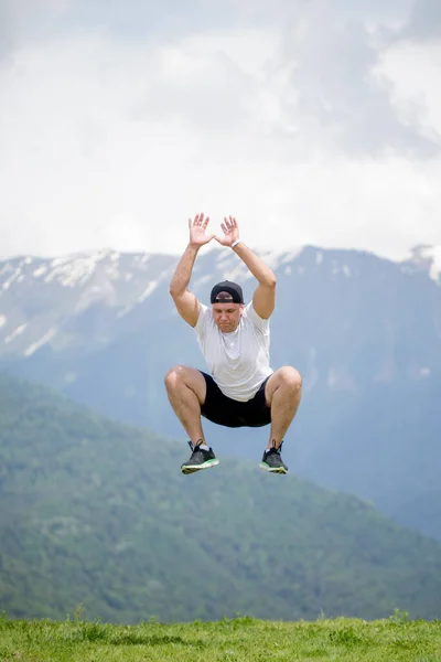 Glad man hoppar på berg till moln himmel. Livsstil Resor känslomässig eufori framgång koncept — Stockfoto