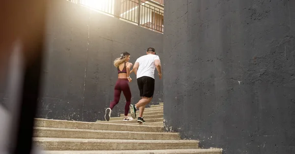 Fitness, sport, människor, motion och livsstil koncept - par som springer på övervåningen på stadstrappan — Stockfoto