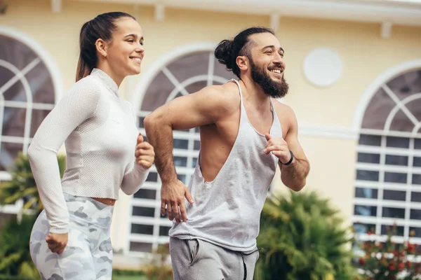 Ejecutar entrenamiento en pareja al aire libre ejercitarse contra el gimnasio. — Foto de Stock