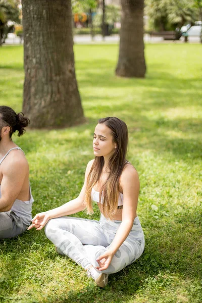 Genç çift dışarıda yoga yapıyor. — Stok fotoğraf
