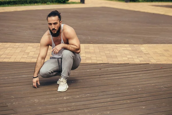 Sportlicher Mann mit muskulösem Körper ruht nach dem Training im Freien — Stockfoto