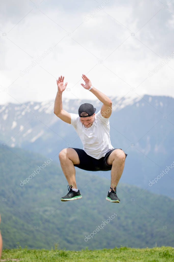 Happy Man jumping at mountains to clouds sky. Lifestyle Travel emotional euphoria success concept