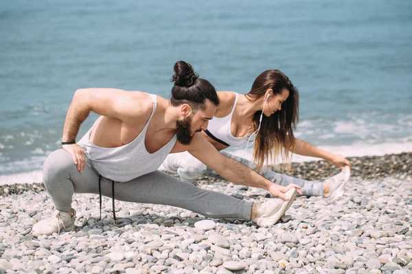 Stretching before everyday jogging on the beach — Stock Photo, Image