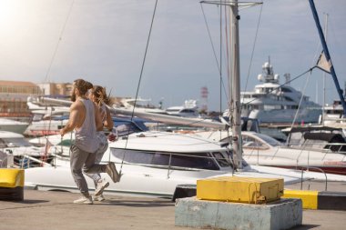 Günbatımında ahşap iskelede koşan genç bir çift.