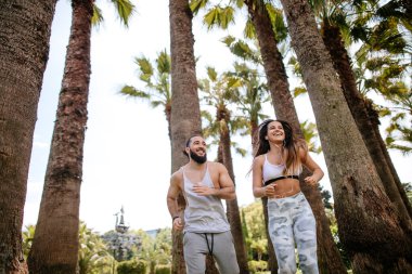 Yaz sabahı parkta koşan genç bir çift.