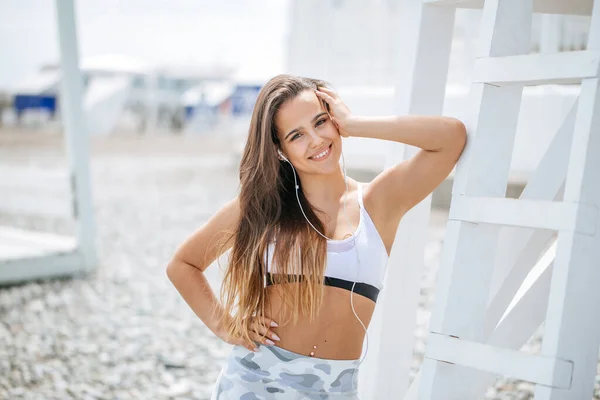 Mulher treinando ioga na praia ao pôr do sol — Fotografia de Stock