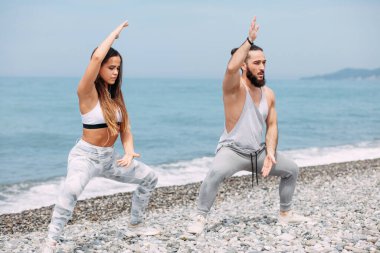 Dışarıda ısınan çiftler, birlikte çömelme hareketleri yapıyorlar.