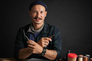 İşyerinde zanaatkar el sanatları aletleriyle poz veriyor.