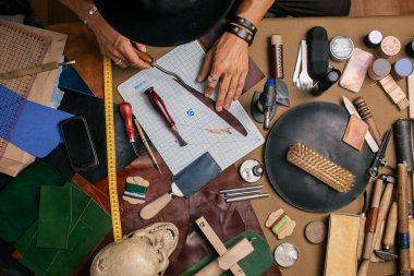 Yakın plan. Bıçakla deri ürünlerine doğranmış bir erkek el ustası. Küçük işletme