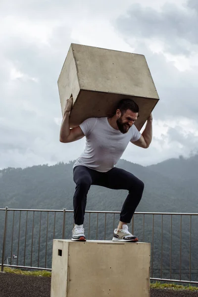 Crossfit uomo facendo squat con peso su montagna natura sfondo all'aperto — Foto Stock