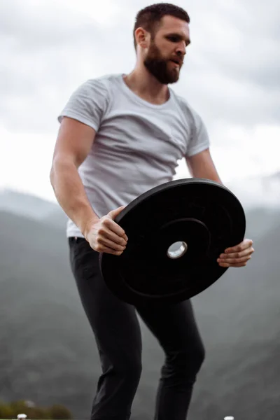 Guapo musculoso hombre guapo mirando montañas desde la cima. —  Fotos de Stock