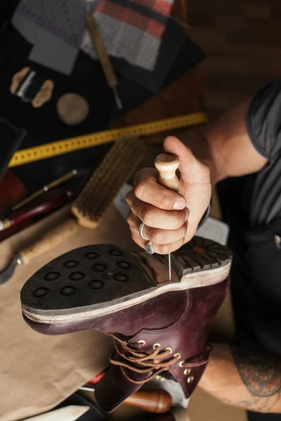Close up de sapateiro mãos produzindo botas em sua oficina de couro — Fotografia de Stock