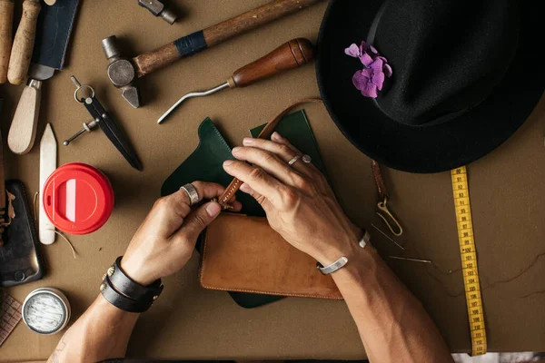 Primer plano del artesano desollador que trabaja con cuero natural utilizando herramientas artesanales. —  Fotos de Stock