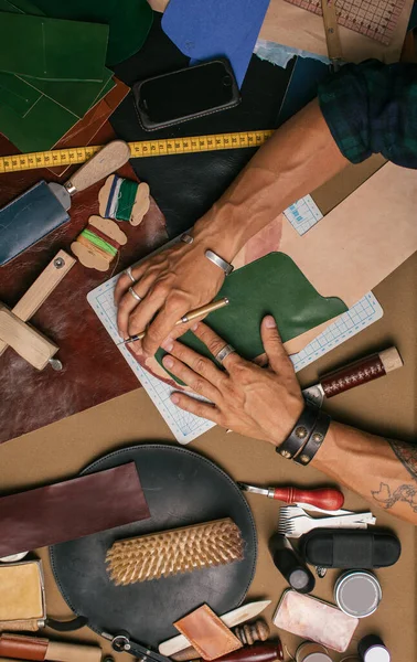 Close up de um sapateiro trabalhando com amostra de couro e martelo na oficina — Fotografia de Stock