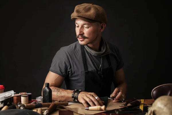 stock image Whiskered shoemaker with making measurments in patterns at table in workshop