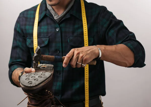 Imagem recortada de um sapateiro medindo um sapato com fita métrica na oficina — Fotografia de Stock