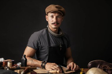 Beyaz arka planda izole edilmiş şapkalı profesyonel ayakkabıcı.