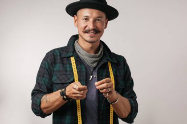 Stüdyonun beyaz arka planında kendine güvenen mutlu adamın yakın çekimi.