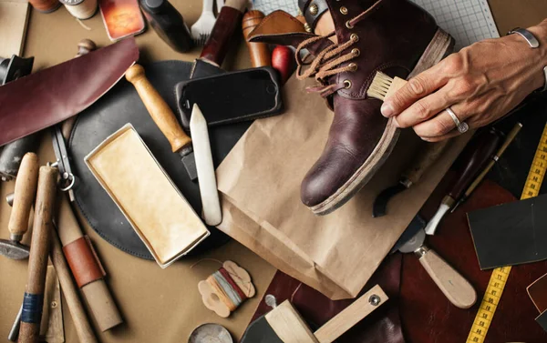 Close up of shoe maker hands producing boots in his leather workshop