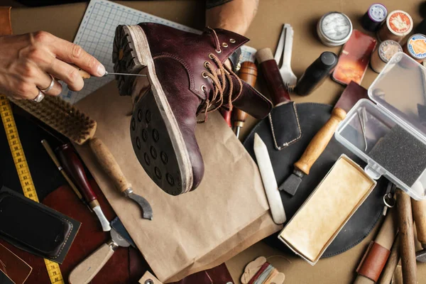 Primer plano de las manos del fabricante de zapatos produciendo botas en su taller de cuero — Foto de Stock