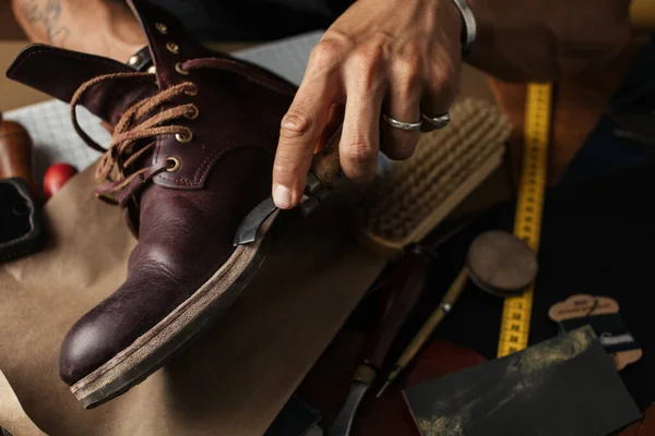 Primer plano de las manos del fabricante de zapatos produciendo botas en su taller de cuero — Foto de Stock