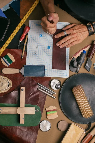 Primer plano de un zapatero que trabaja con textil de cuero y martillo en un taller —  Fotos de Stock