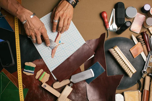 Primer plano. Master de mano masculino cortado con un cuchillo a los productos de la piel. Pequeñas empresas — Foto de Stock