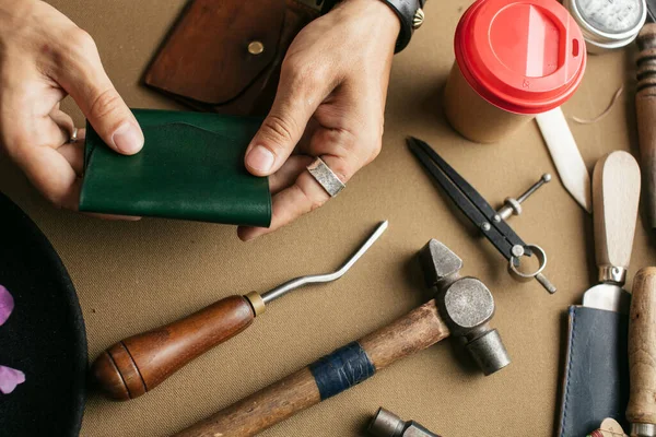 Мастер кожаных изделий и кожаные бумажники ручной работы. Рабочий процесс в мастерской. — стоковое фото