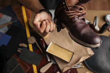 Ayakkabı imalatçısının ellerinde deri atölyesinde çizme üretirken.