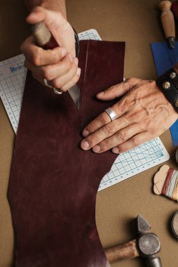 Deri atölyesinde el yapımı deri cüzdan üretme süreci.