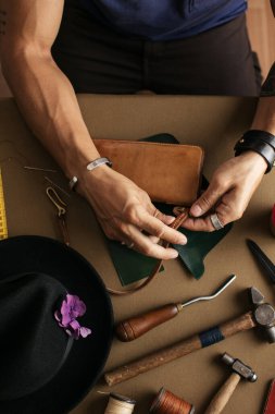 Yakın plan. Bıçakla deri ürünlerine doğranmış bir erkek el ustası. Küçük işletme