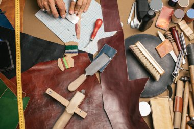 Yakın plan. Bıçakla deri ürünlerine doğranmış bir erkek el ustası. Küçük işletme