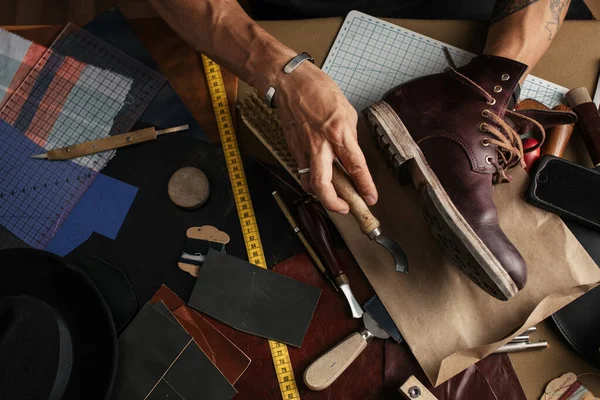 Gros plan des mains de fabricant de chaussures produisant des bottes dans son atelier de cuir — Photo