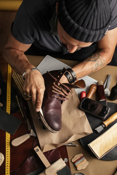 Gros plan des mains de fabricant de chaussures produisant des bottes dans son atelier de cuir — Photo