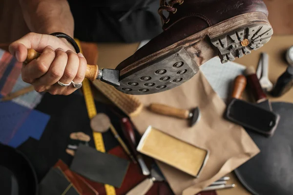 Крупный план обуви руки производителя сапоги в его кожаной мастерской — стоковое фото