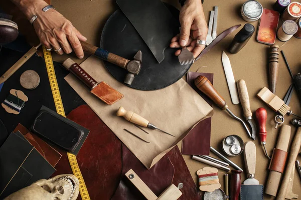 Primer plano del artesano desollador que trabaja con cuero natural utilizando herramientas artesanales. — Foto de Stock