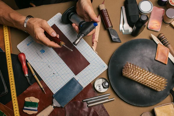 Primer plano de un zapatero que trabaja con muestra de cuero y martillo en el taller —  Fotos de Stock